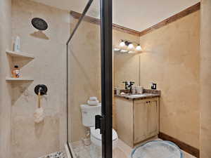 Bathroom featuring a stall shower, vanity, and ornamental molding