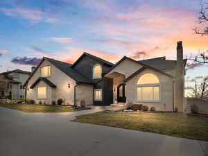 View of front facade featuring a yard, a chimney, brick siding, and a shingled roof