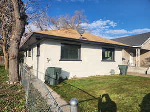 View of side of property with brick siding and roof with shingles