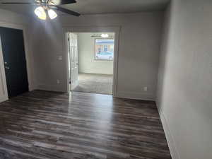 Spare room with ceiling fan and dark wood-style floors