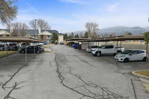 Covered parking lot featuring a mountain view and a residential view