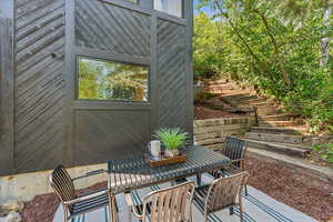 View of patio with outdoor dining space and stairs