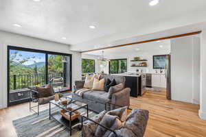Living room with a mountain view, light wood-style floors, and recessed lighting