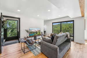 Living area with light wood finished floors, recessed lighting, and a textured ceiling