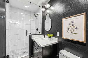 Bathroom with vanity, a shower stall, and recessed lighting