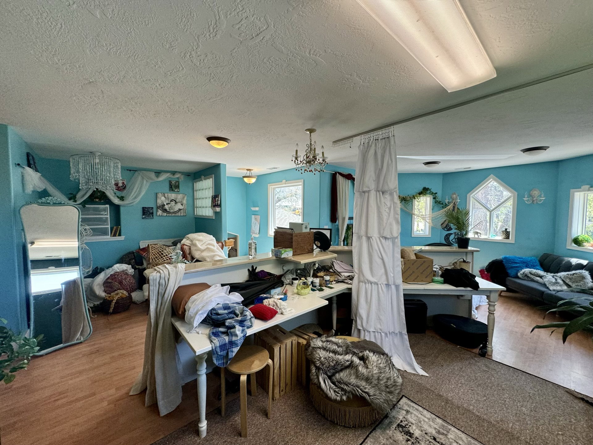 Bedroom with a textured ceiling, multiple windows, a chandelier, and wood finished floors