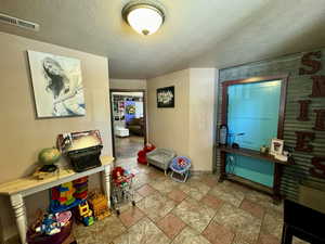 Entrance foyer featuring stone finish flooring and a textured ceiling