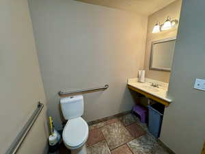 Half bath featuring stone tile floors and vanity