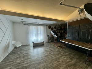 Mudroom with a textured ceiling, dark wood-style flooring, a decorative wall, and lofted ceiling