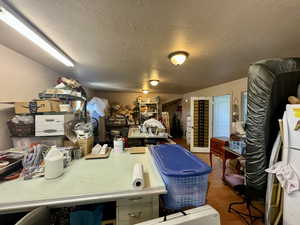 Misc room featuring a textured ceiling and dark wood-style floors