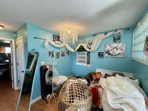Bedroom featuring a chandelier, wood finished floors, a closet, and a textured ceiling