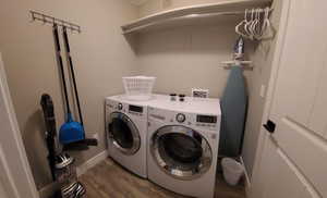 Washroom featuring dark wood-style flooring and washer and dryer