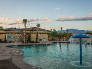 Pool at dusk with a community pool, a patio, and a mountain view