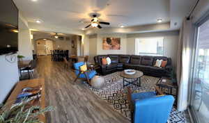 Living room featuring wood finished floors, arched walkways, a ceiling fan, radiator, and recessed lighting