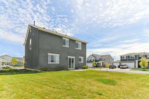 Back of property featuring a residential view, a yard, and stucco siding