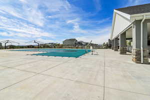 Community pool featuring a patio and a residential view