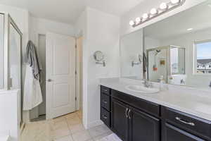 Full bathroom with a shower stall, vanity, and light tile patterned floors