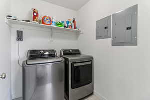 Laundry area with electric panel and washing machine and clothes dryer
