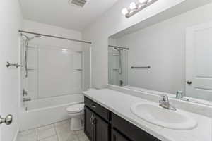 Bathroom featuring vanity, shower / bath combination, and light tile patterned floors