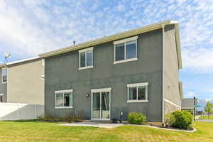 Rear view of house with stucco siding and stone siding