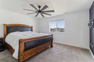Carpeted bedroom with a ceiling fan and baseboards