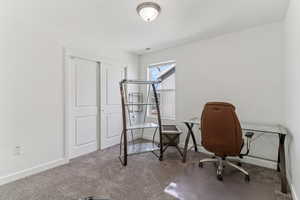 Carpeted office space featuring baseboards