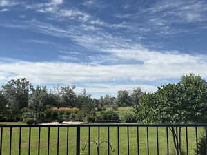 View of grassy yard with a balcony