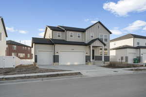 View of front of home featuring board and batten siding, driveway, a gate, and a garage