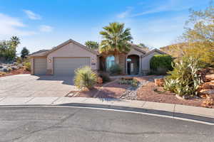 View of front of property featuring an attached garage, driveway, stucco siding, and a tiled roof