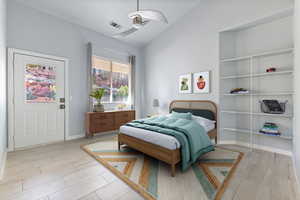 Bedroom featuring vaulted ceiling, wood tiled floors, and ceiling fan
