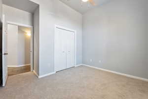 Unfurnished bedroom with carpet floors, a closet, and ceiling fan
