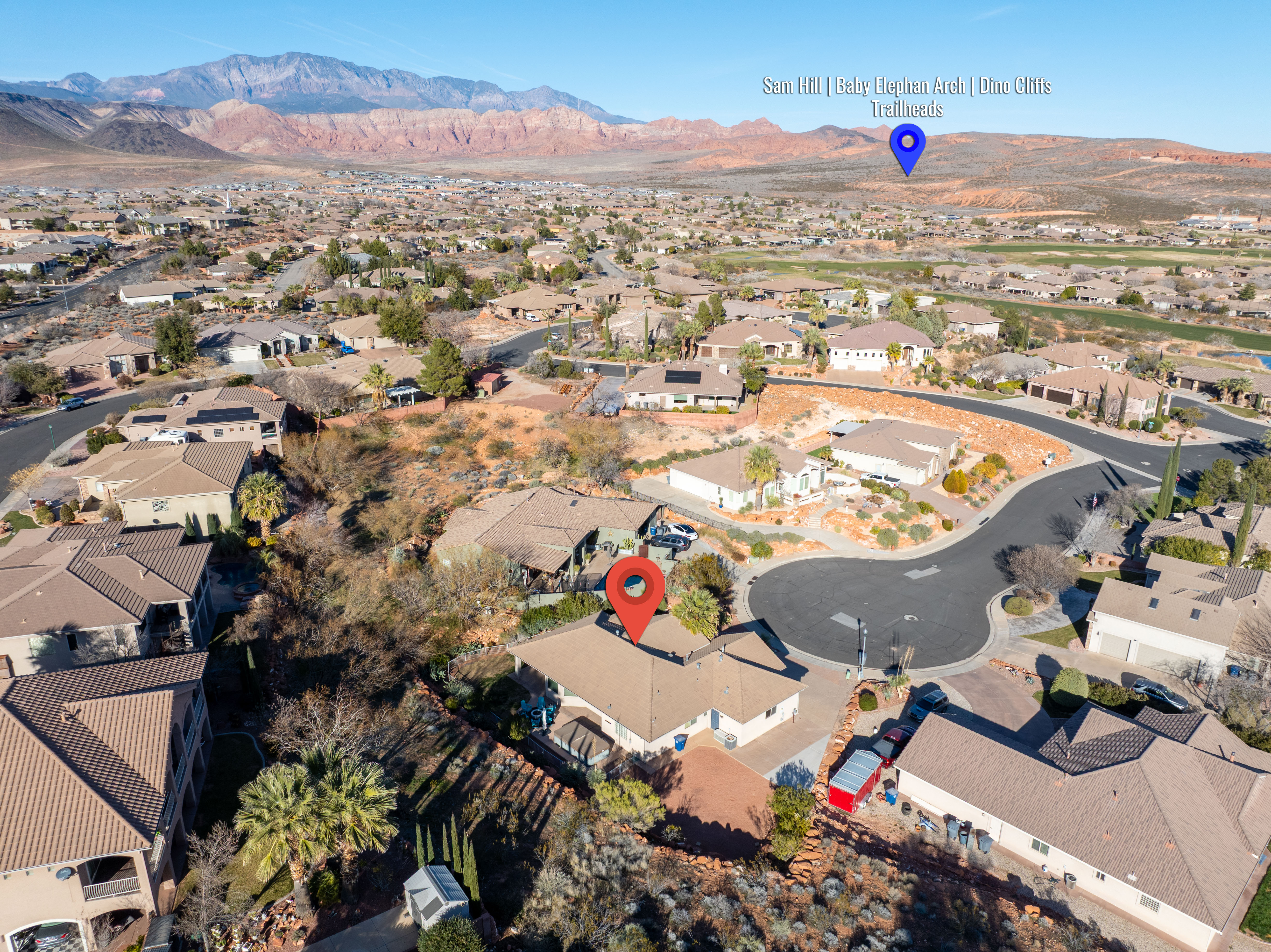Aerial view of property and surrounding area with nearby suburban area and a mountainous background