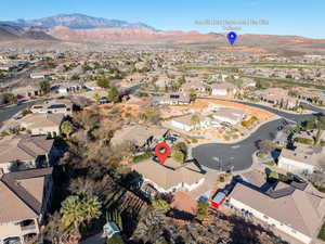 Aerial view of property and surrounding area with nearby suburban area and a mountainous background