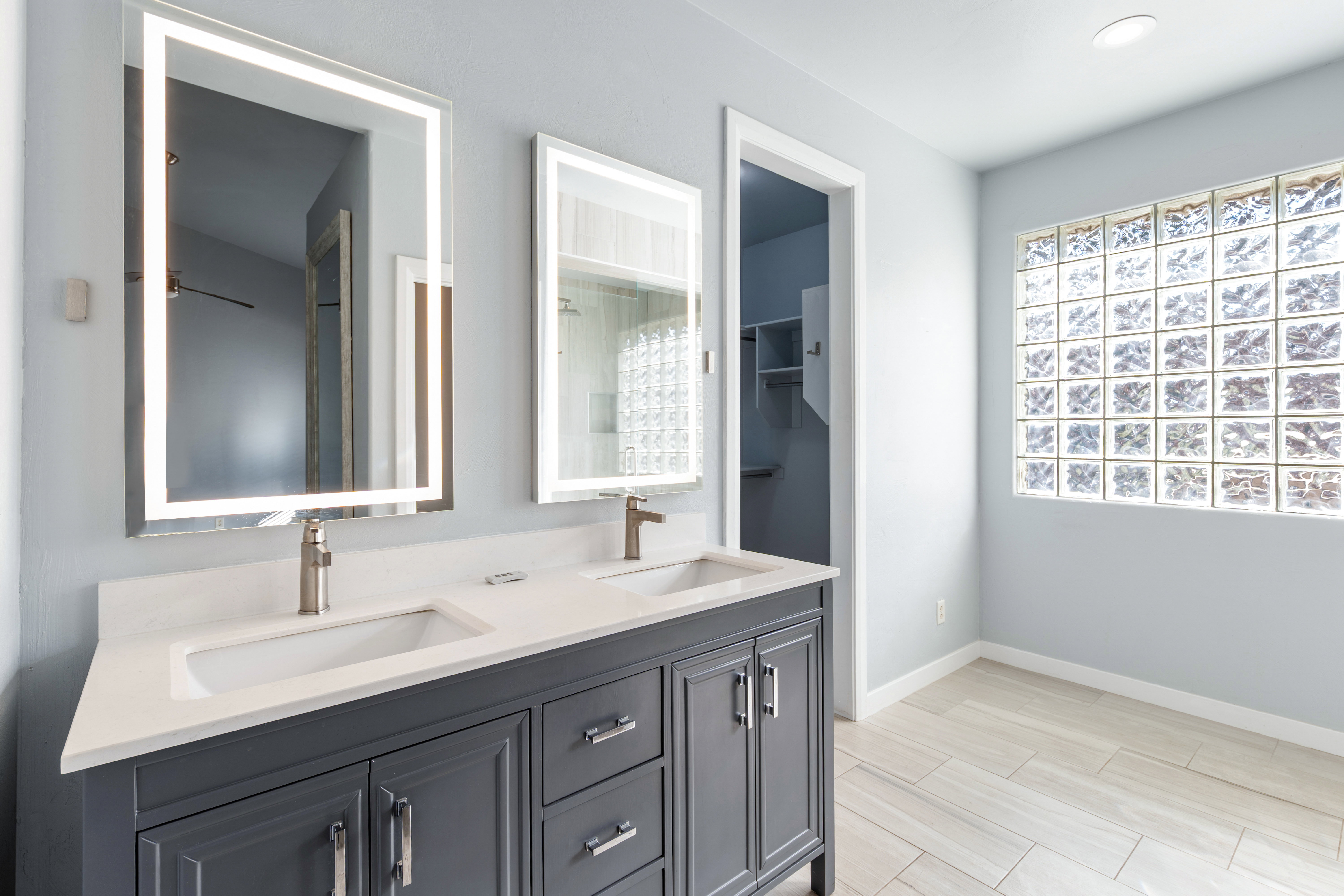 Full bath with double vanity and wood finish floors