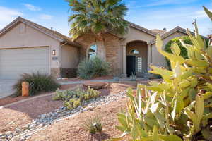 Ranch-style home with stone siding, stucco siding, a garage, and concrete driveway