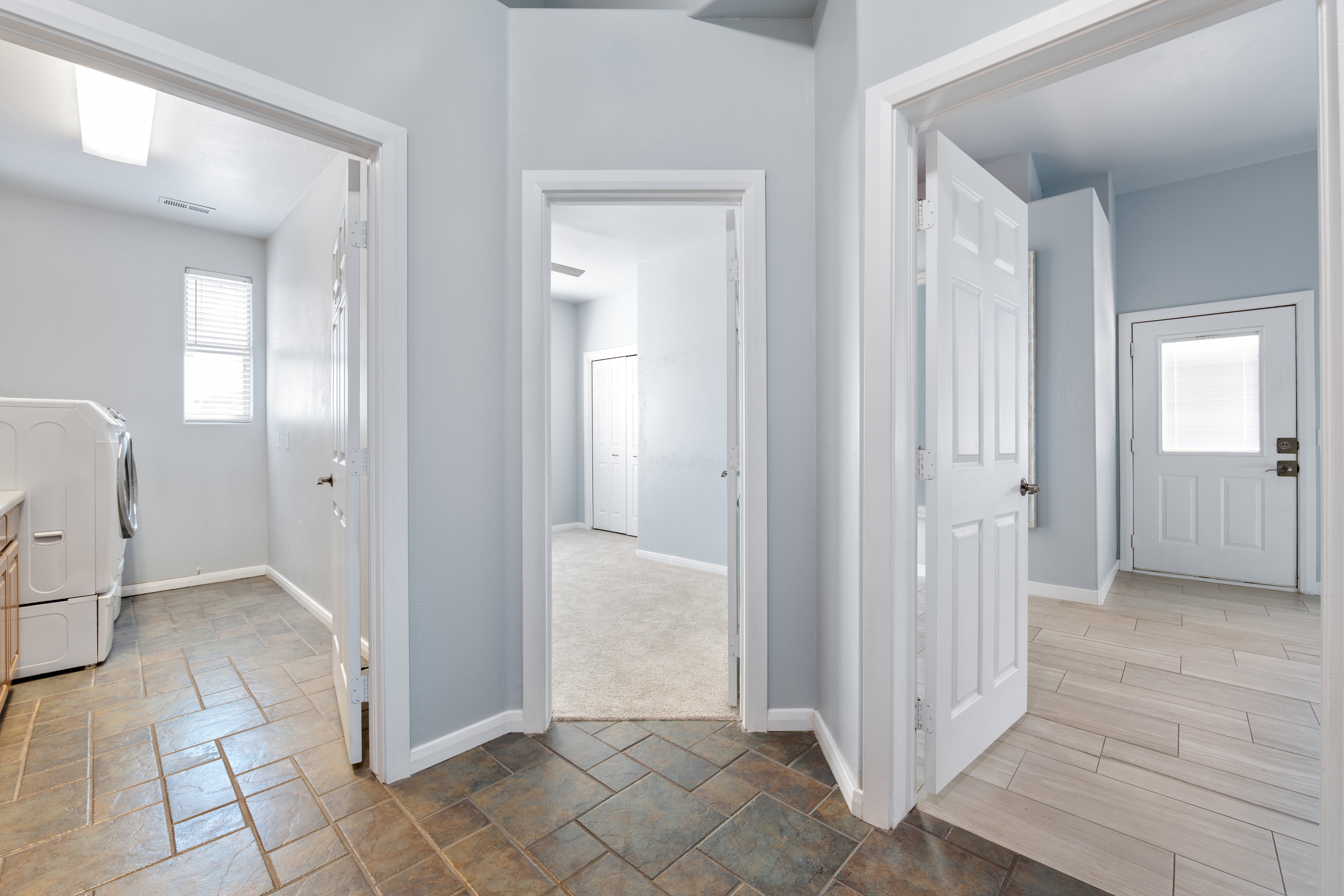 Laundry area with washer / clothes dryer and stone tile floors