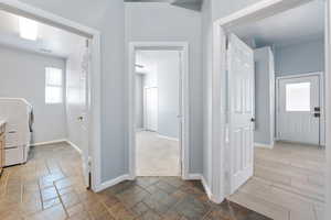 Laundry area with washer / clothes dryer and stone tile floors