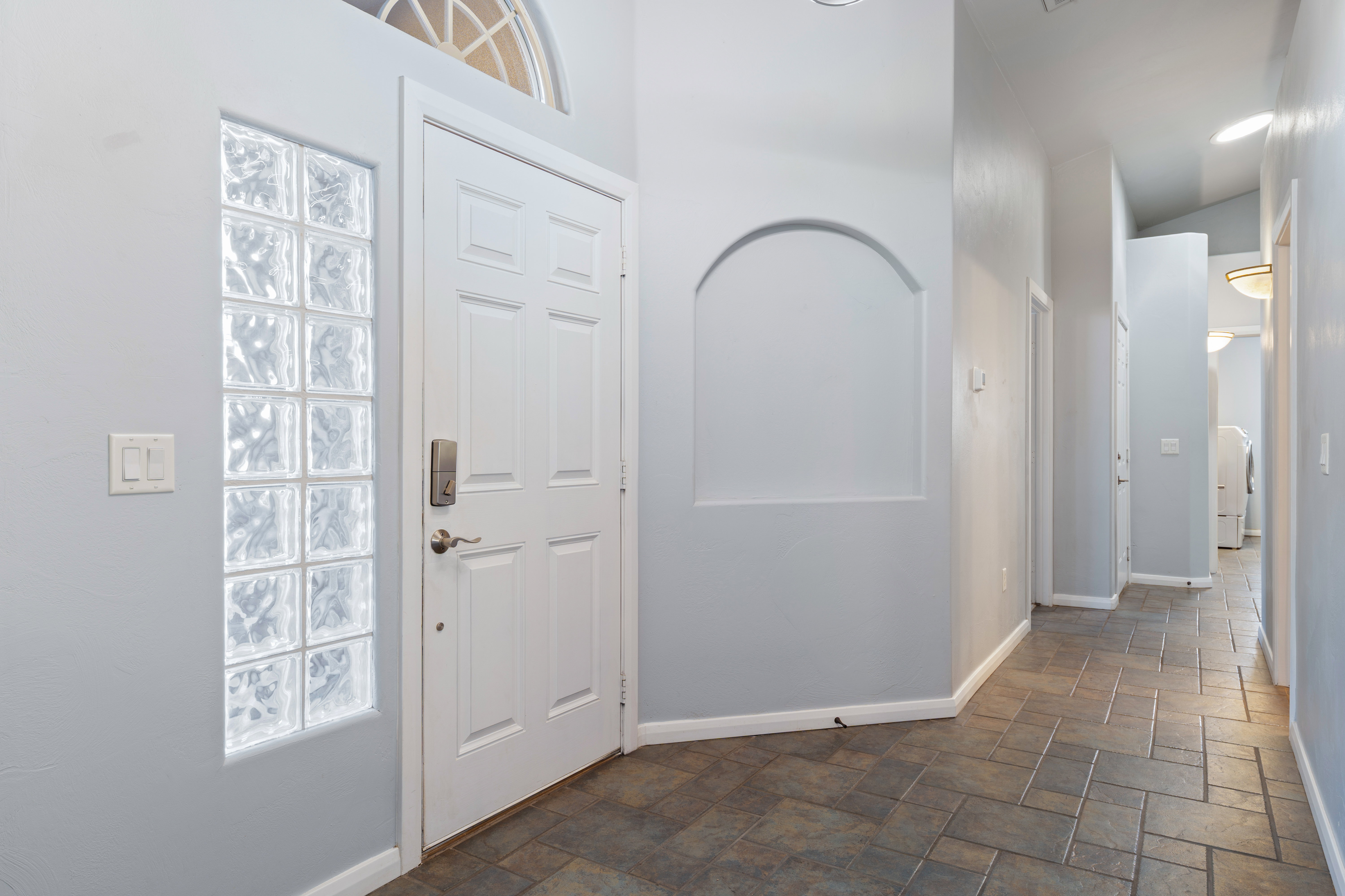 Foyer entrance featuring dark stone finish floors and plenty of natural light