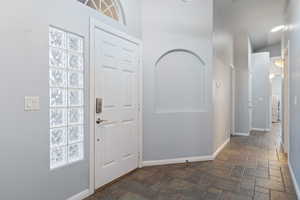 Foyer entrance featuring dark stone finish floors and plenty of natural light