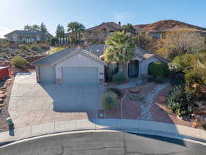 View of front of house featuring concrete driveway, stone siding, a garage, stucco siding, and a tiled roof
