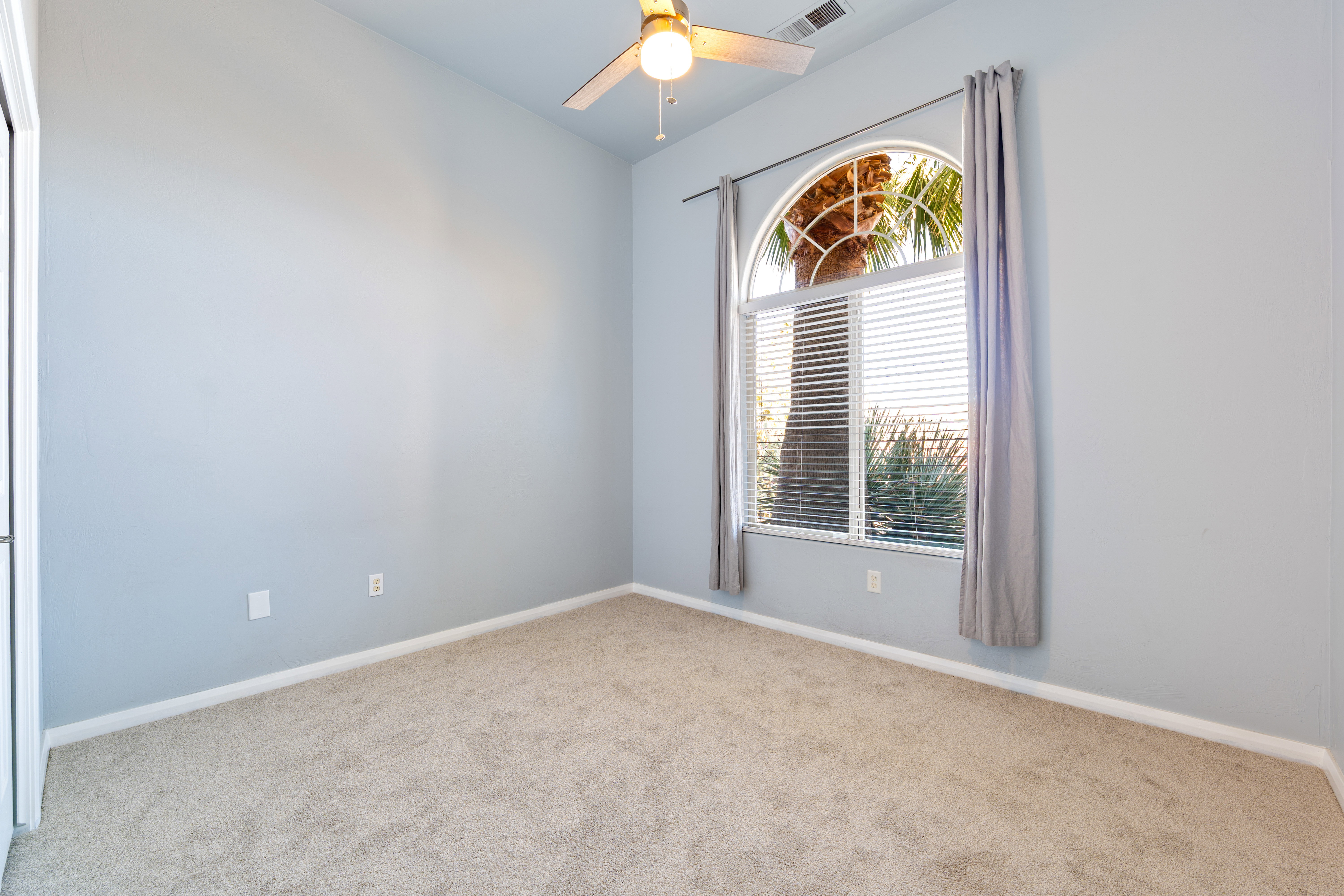 Carpeted spare room with baseboards and a ceiling fan