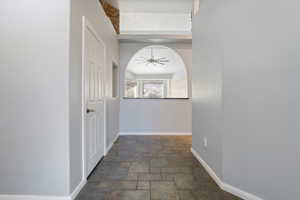 Hallway with arched walkways and dark stone finish floors