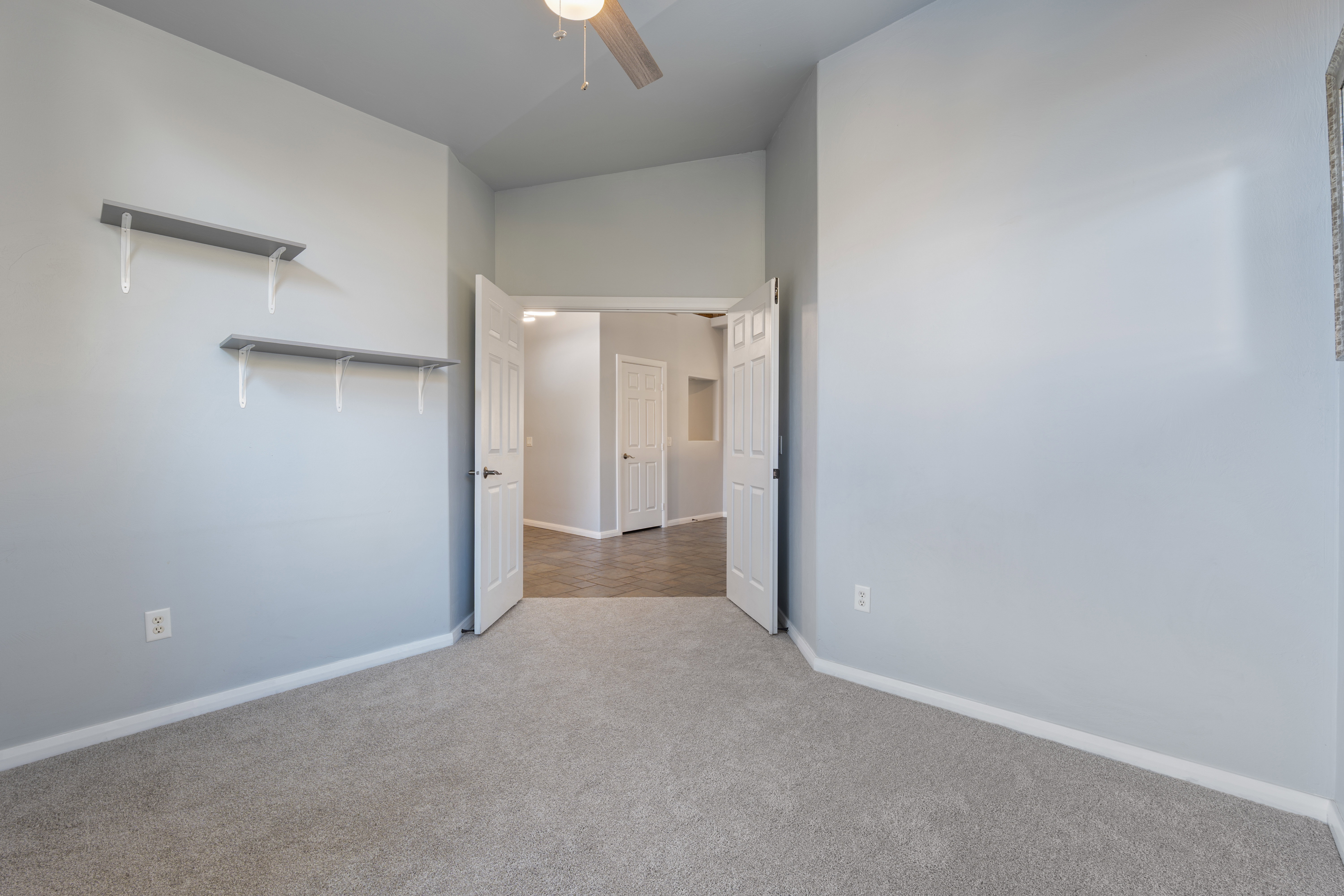 Unfurnished bedroom with light carpet and ceiling fan