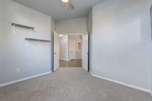 Unfurnished bedroom with light carpet and ceiling fan