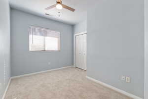 Unfurnished bedroom with carpet floors, a ceiling fan, and a closet