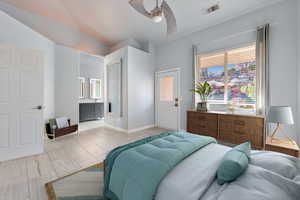 Bedroom with connected bathroom, ceiling fan, and lofted ceiling