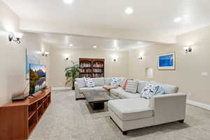 Living room featuring light carpet, recessed lighting, and beam ceiling