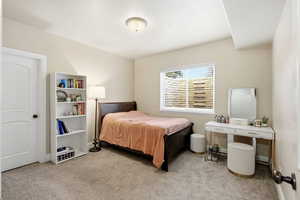 Bedroom featuring light colored carpet and baseboards