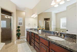 Full bathroom with double vanity, a stall shower, light tile patterned floors, and a garden tub