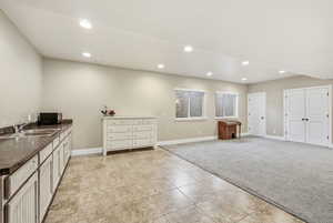 Kitchen featuring light carpet, dark countertops, black microwave, recessed lighting, and light tile patterned floors